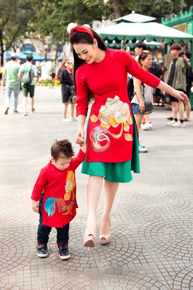 赤いアオザイを着た子供と女性